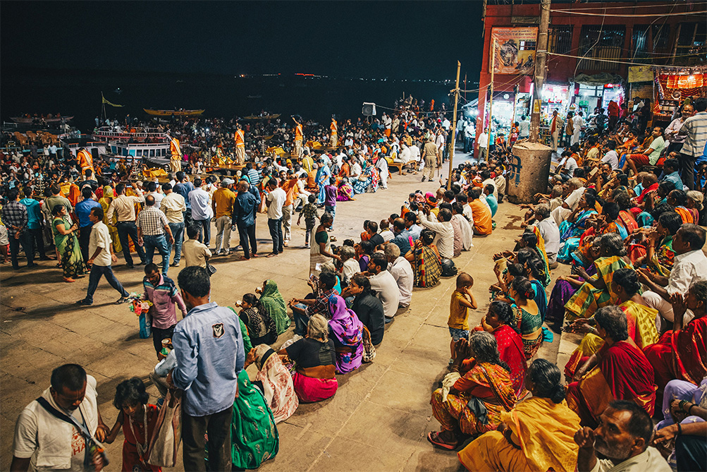 Crowd of people sitting on steps in Varanasi